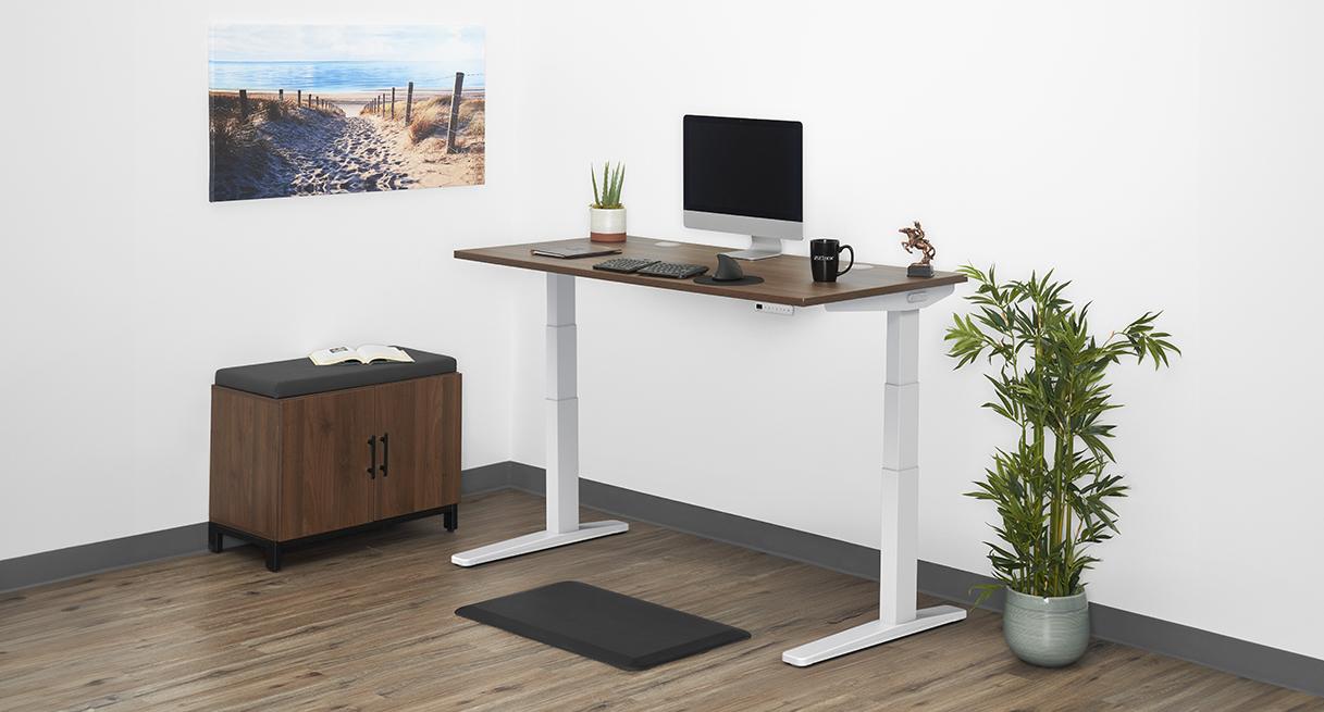 UPLIFT V3 with a white C-frame and walnut laminate desktop in a furnished workspace.